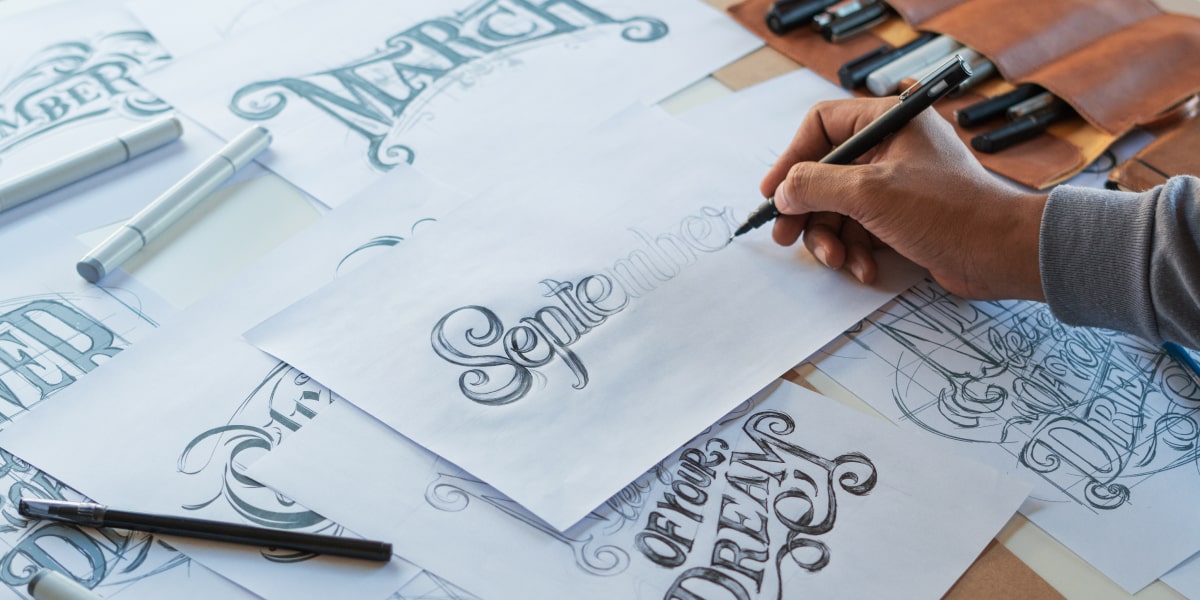 A designer hand-drawing different typography styles