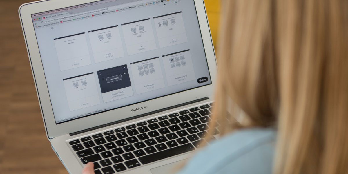 A designer uses UI design tools on a laptop