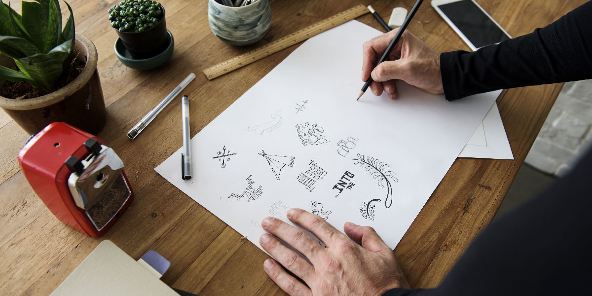 A designer sketching on a piece of paper