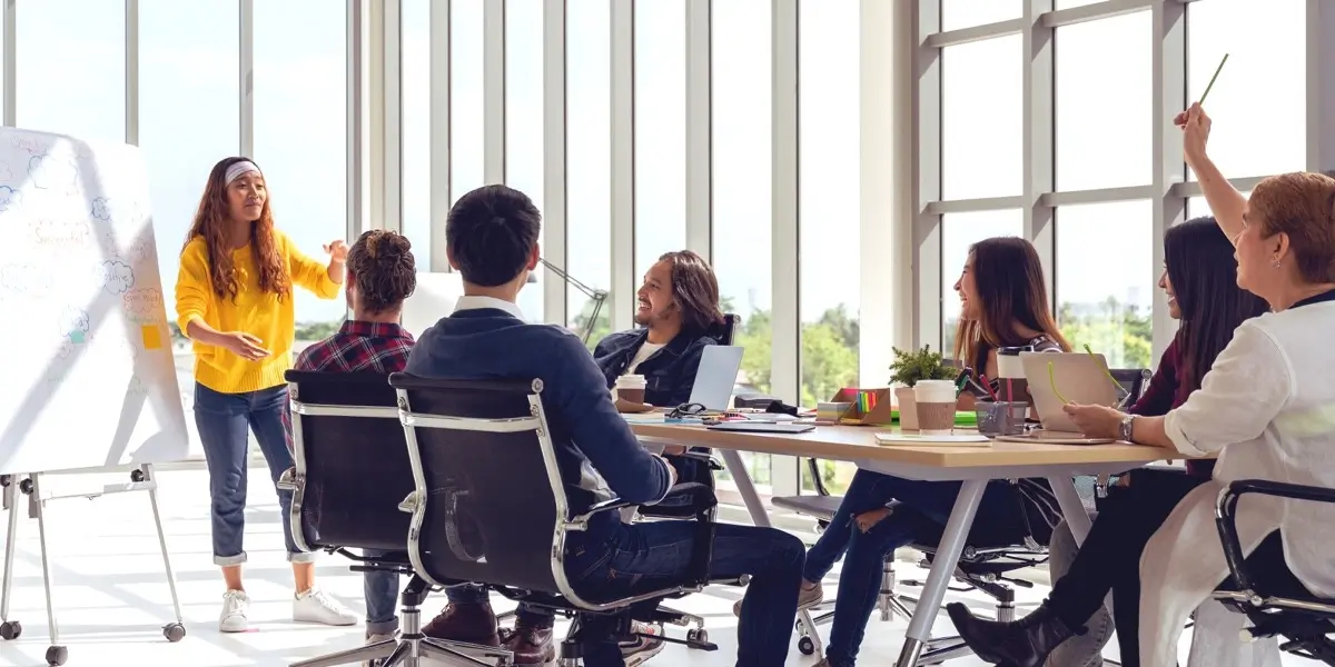 A group of product designers sitting around a table in a sunny office