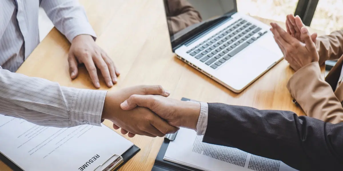 A data analyst job applicant shaking hands with an interviewer