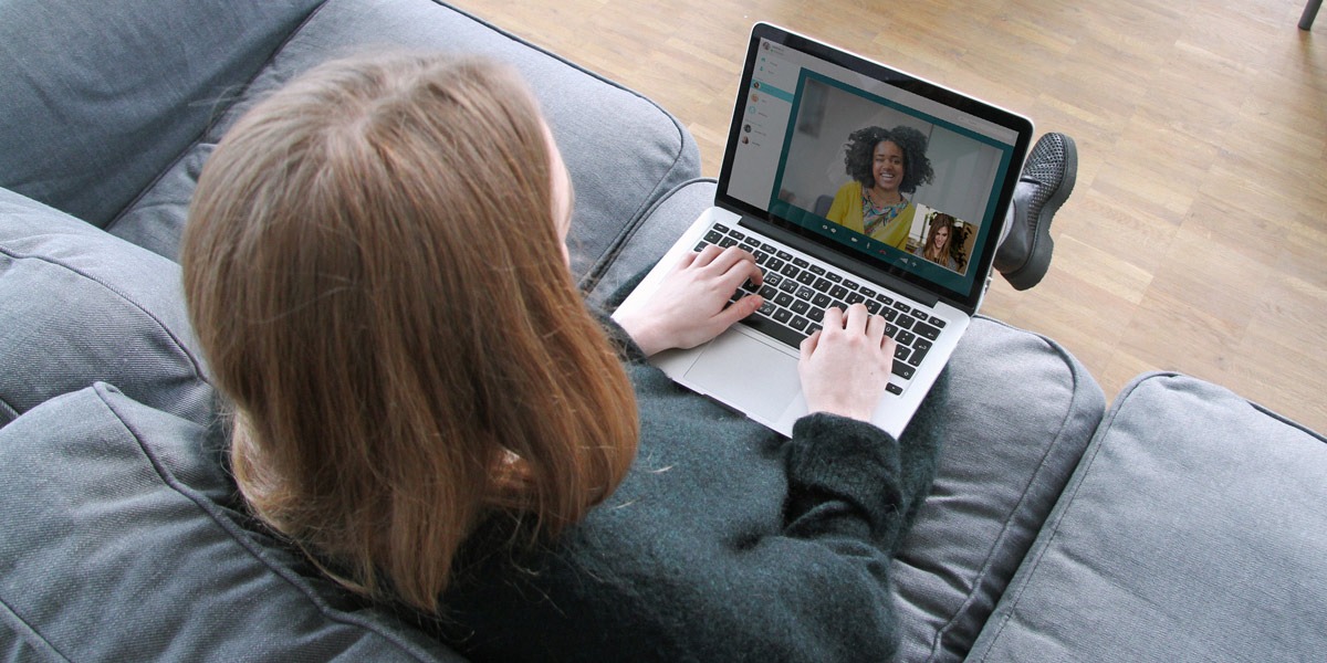 A UX design student sitting on a sofa, taking a video call with a UX design mentor