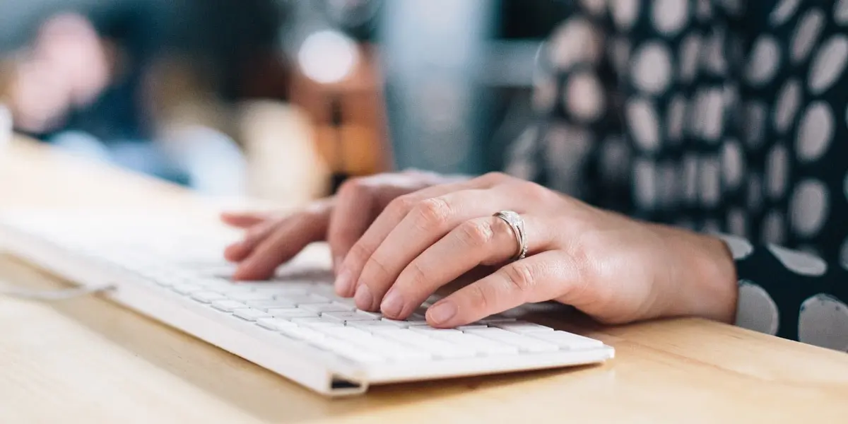 A pair of hands typing on a keyboard