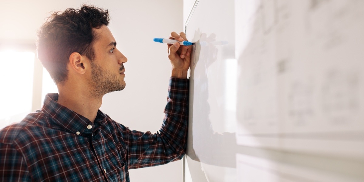 A UX designer drawing ideas out on a whiteboard