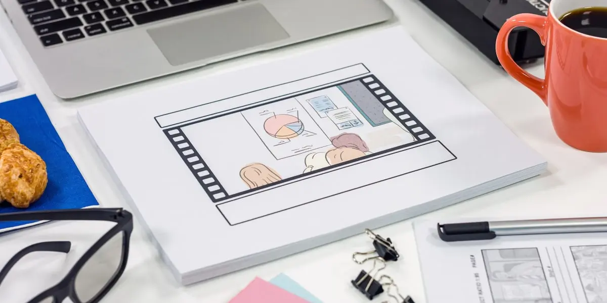 A hand-drawn storyboard on a table next to a laptop