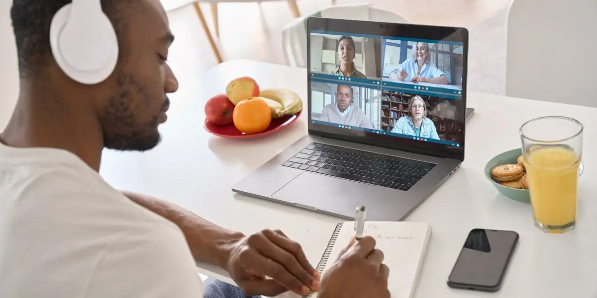 A digital marketing bootcamp student sitting at a desk, on a video call with other students