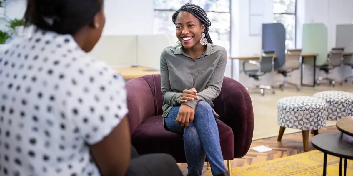 An aspiring social media manager and an employer sitting opposite each other during an interview