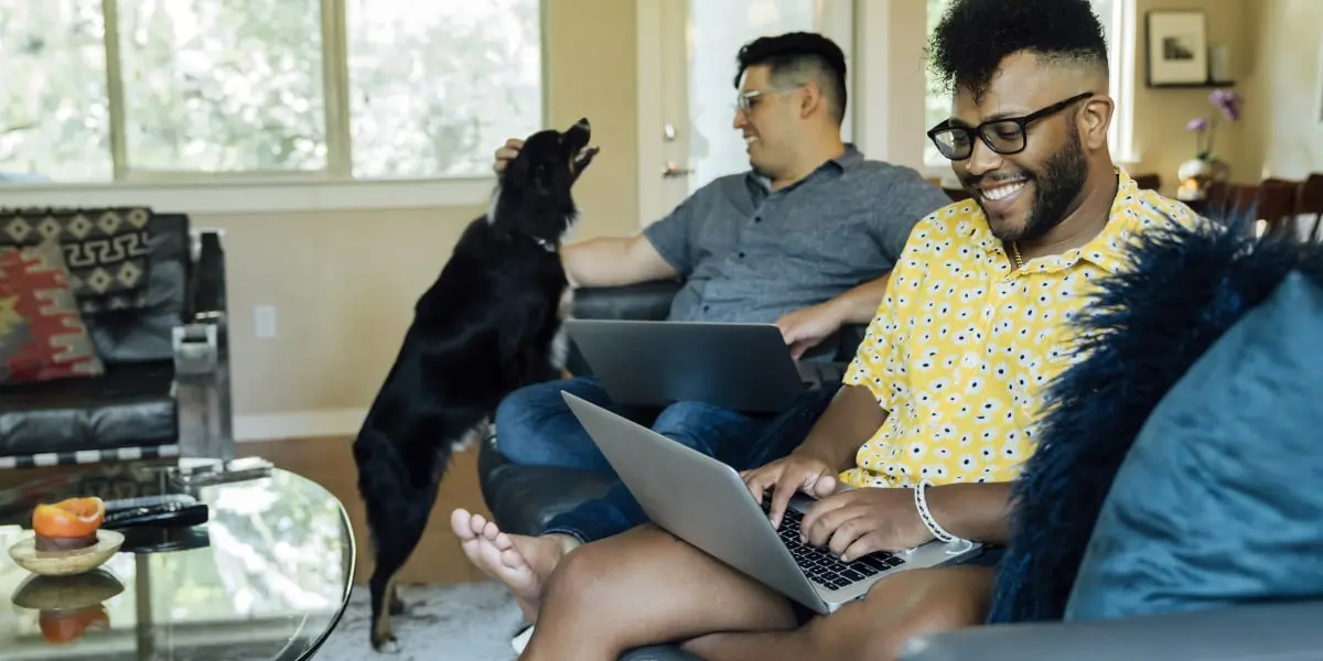A social media specialist working from home, sitting on a sofa with a dog