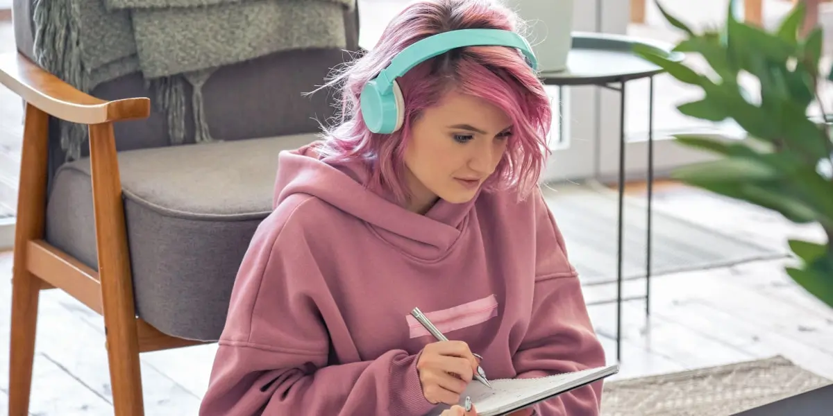 A social media manager sitting on the floor, wearing headphones