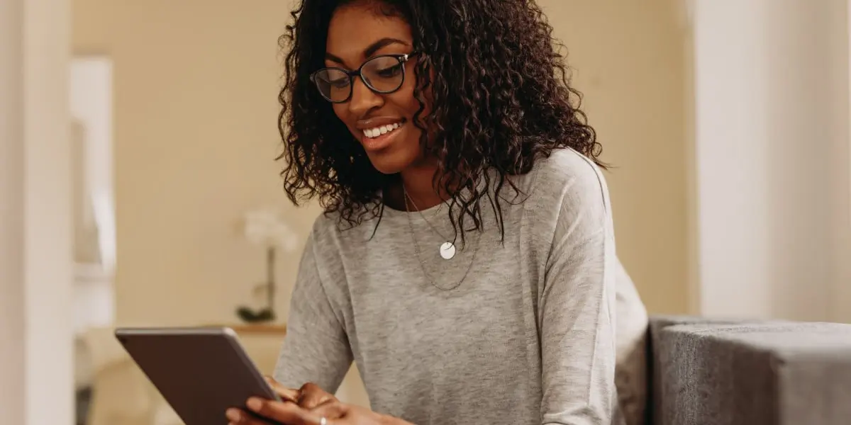 A digital marketing manager smiling, looking at an iPad