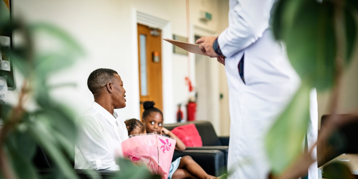 Image showing a family in a hospital waiting room getting good news from a doctor.