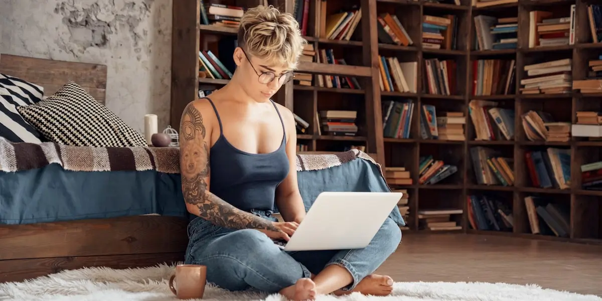 Woman sitting in her bedroom learning how to become a digital marketer