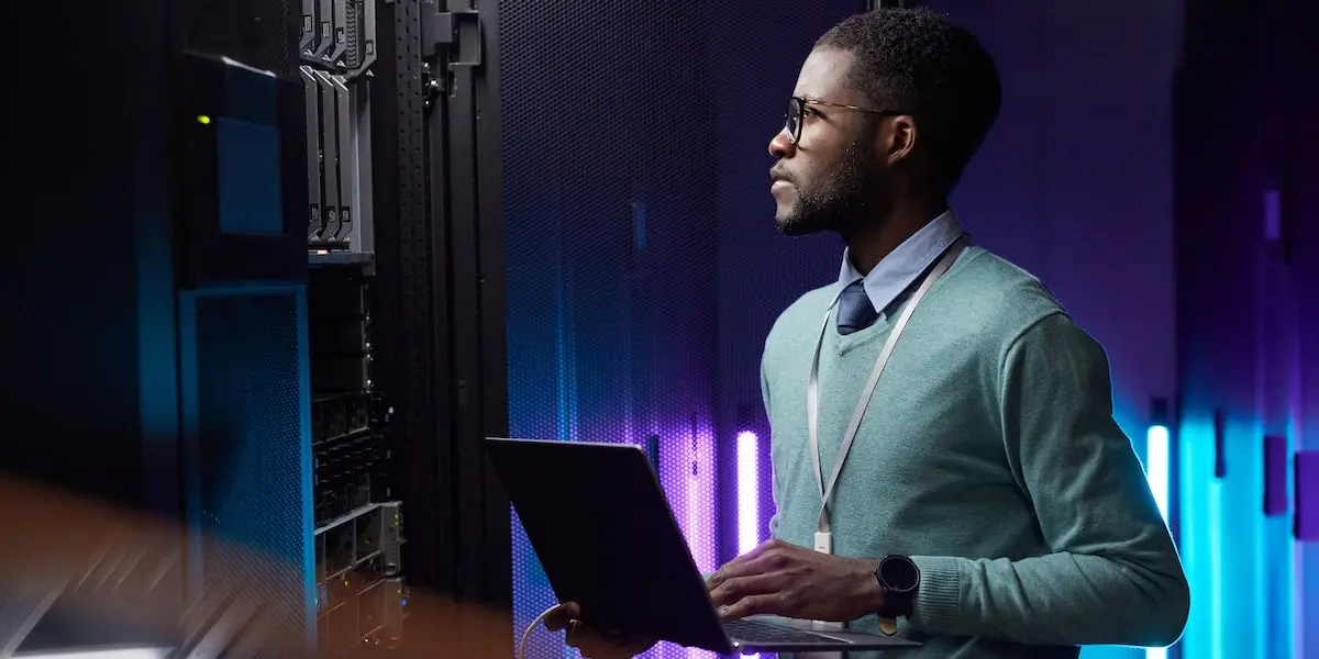 Man standing in server room learning how to use SQL