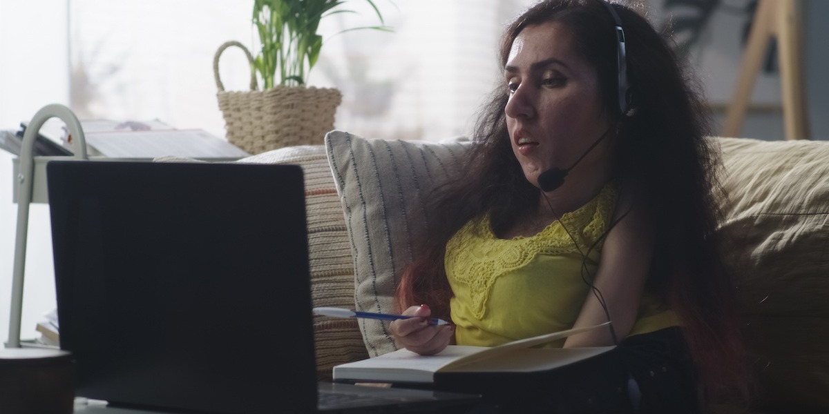 A differently abled product manager on a videocall draws up a product roadmap in her home office.