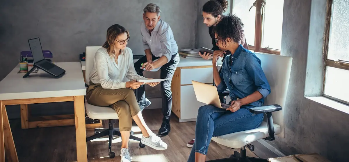 A product manager meets with their team in an office to go over a product roadmap.