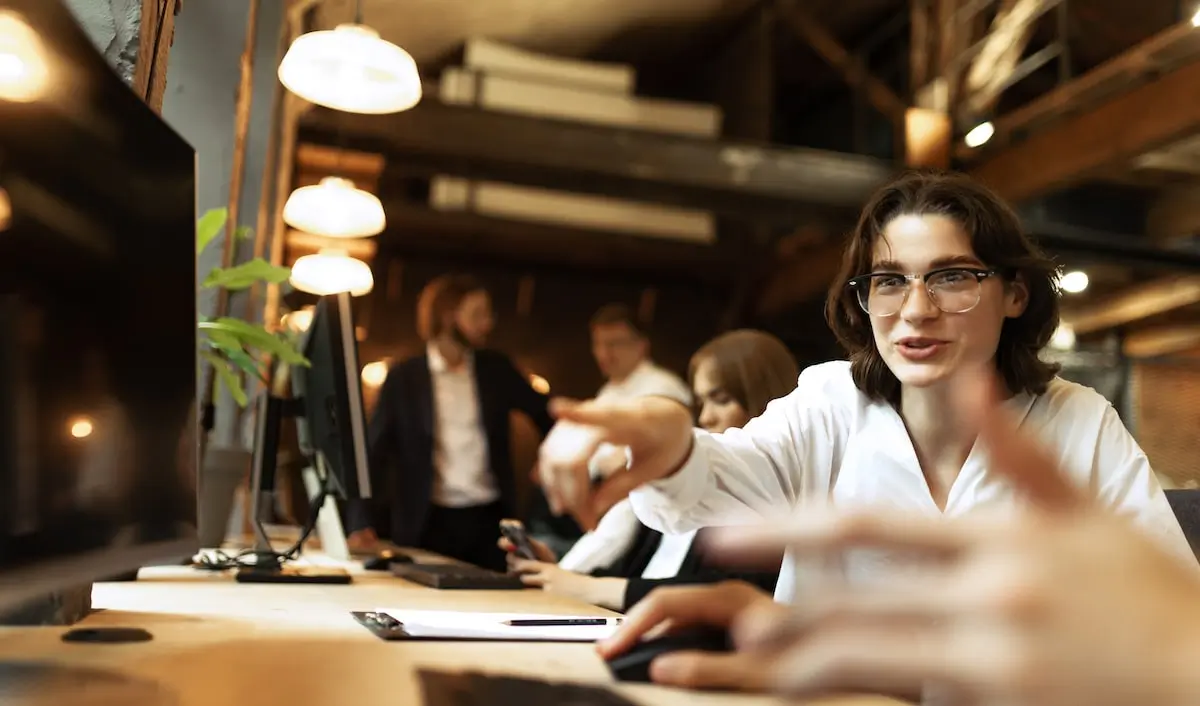 A coder communicates to a colleague in a start-up office.