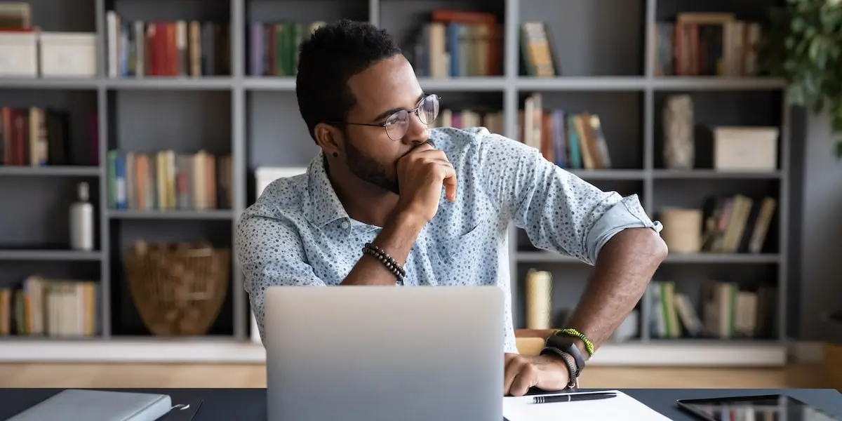 Man sits and thinks about off page SEO in front of his laptop