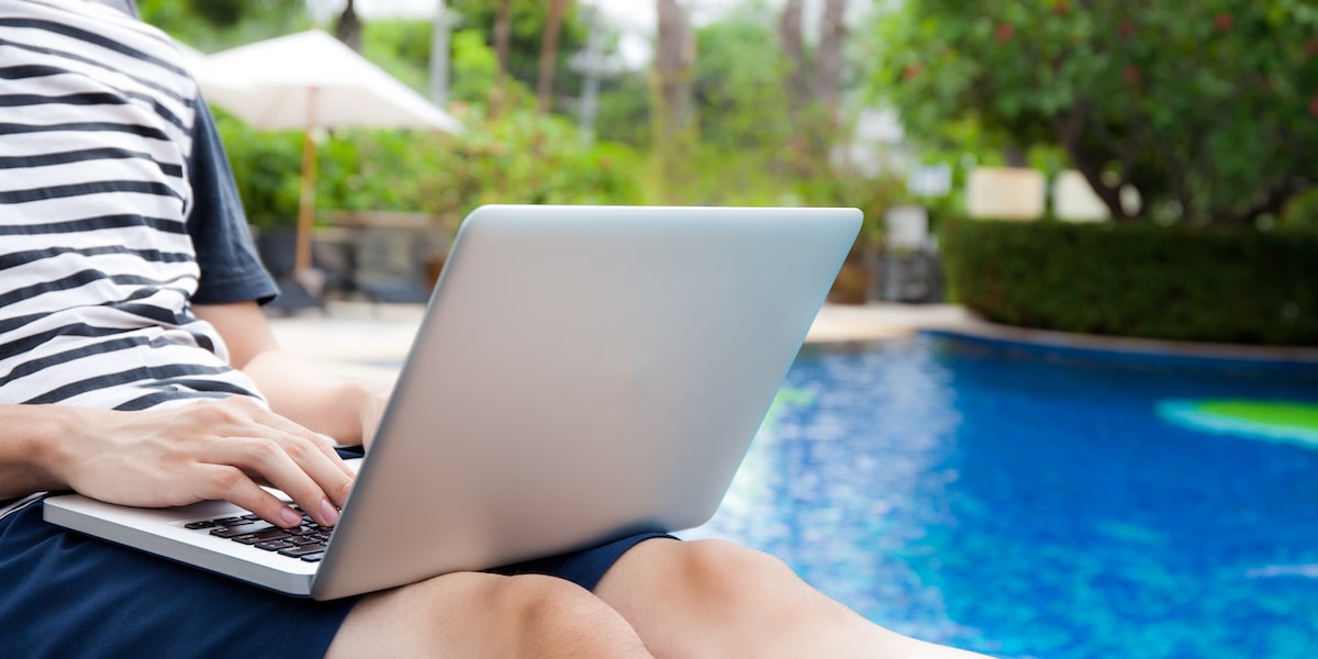 A man in a tshirt learns about AARRR pirate metrics on his laptop by a pool.