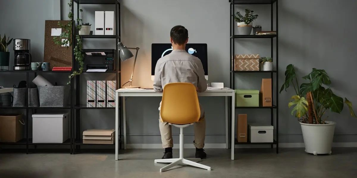 A man taking coding bootcamps with job guarantee in his home office.