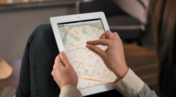 User pinching the screen on a tablet to zoom out on a map.