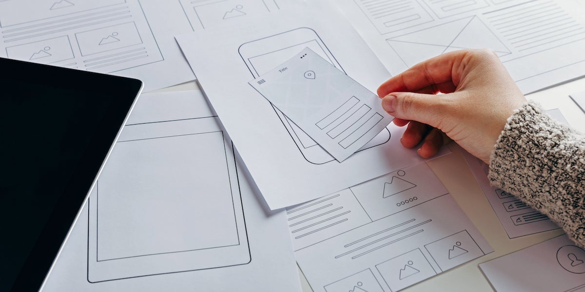 A UI designer works on a wireframe of a mobile app interface