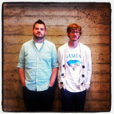 The two Bootstrap creators, web developers Mark Otto and Jacob Thornton standing next to a blank wall