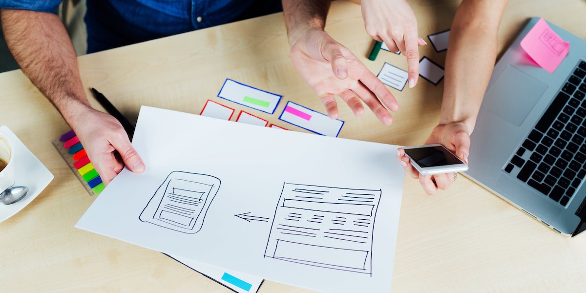 Two UI designers work on different mock-ups for an app UI