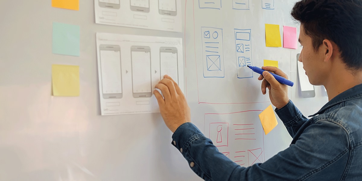 A user experience designer drawing on a whiteboard